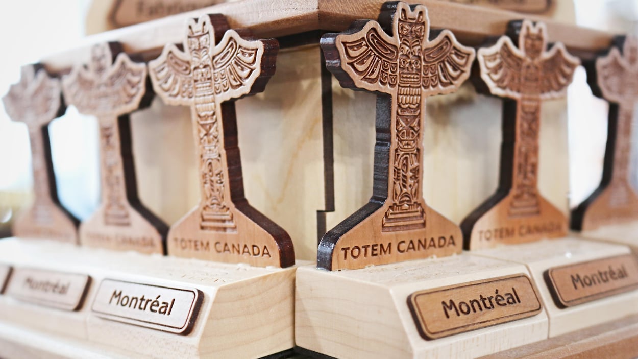 Une série de petites statuettes de bois en forme de totems sont posées sur l'étagère d'une boutique de souvenirs du Vieux-Port de Montréal.