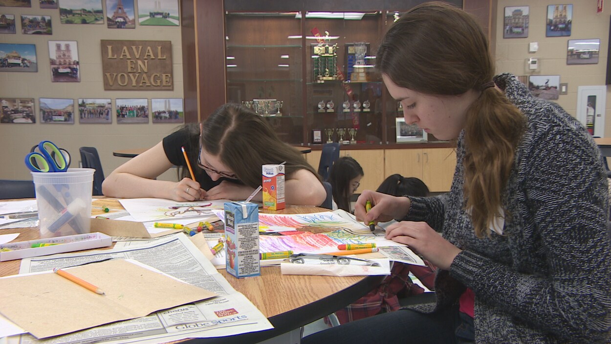 Deux élèves sont concentrées à dessiner des oeuvres pour l'oeuvre d'art publique qui sera présentée au parc de la Confédération de Regina.