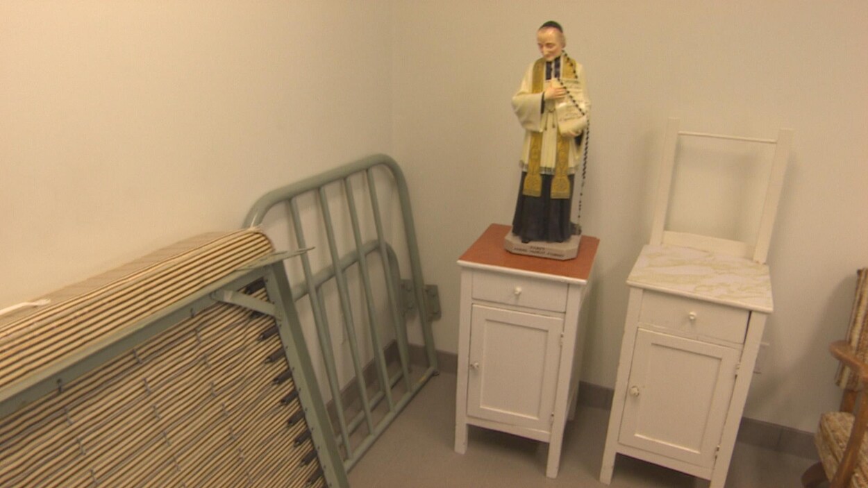 Un vieux lit, des meubles et une statue d'un prêtre. Un vieux lit, des meubles et une statue d'un prêtre.