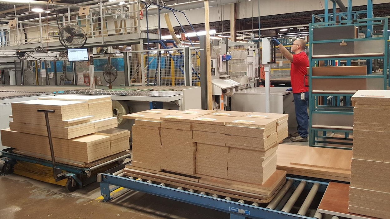 Un homme en train d'utiliser une machine, dans l'usine Artopex de Granby.