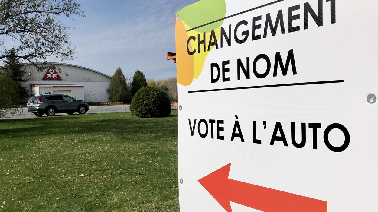 Une affiche indique la voie à suivre pour le vote à l'auto.