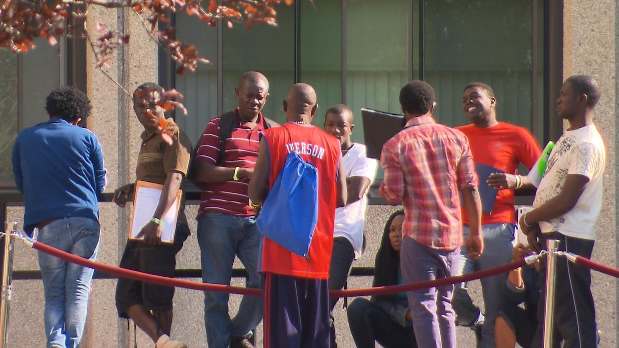 Une dizaine de demandeurs d'asile font la file à l'extérieur pour obtenir leur chèque d'aide sociale à Montréal