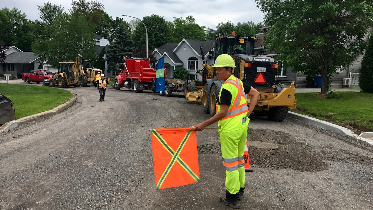 Des travailleurs procèdent à des travaux d'asphaltage.