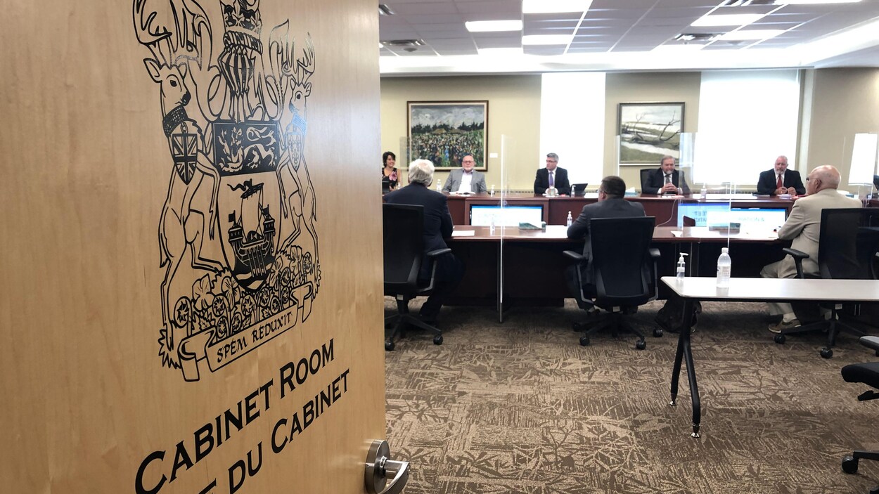 Des députés assis de tôt et la porte de la salle du Cabinet entrouverte.