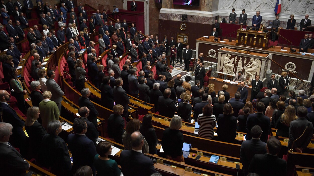 Les députés de l'Assemblée nationale française se tiennent debout.