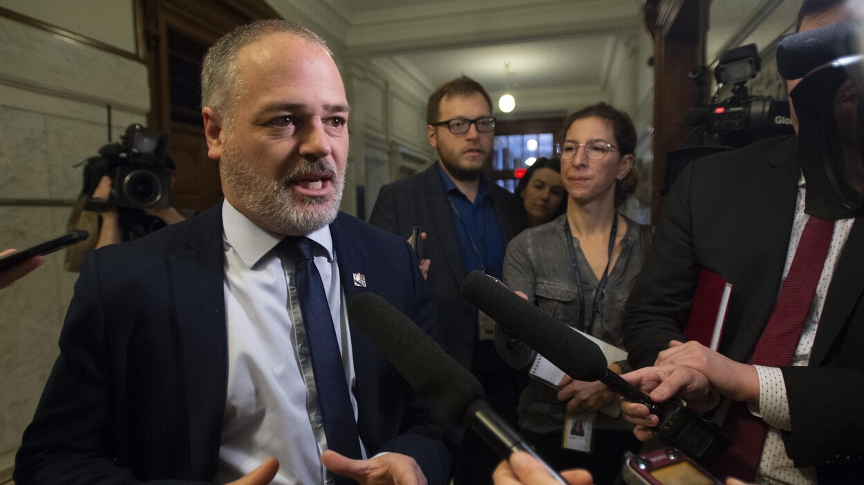 Jonatan Julien répondant aux questions des journalistes dans les corridors de l'Assemblée nationale.