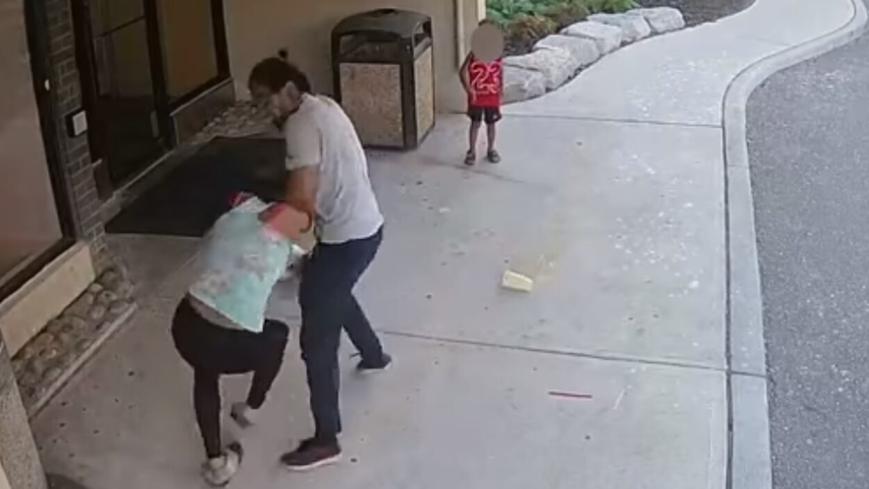 Photo d'un homme qui tire sur les cheveux d'une femme à deux pas d'un enfant. Photo d'un homme qui tire sur les cheveux d'une femme à deux pas d'un enfant.