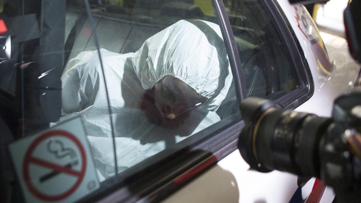 On voit Ayanle Hassan Ali arriver dans une voiture de police au tribunal de Toronto.