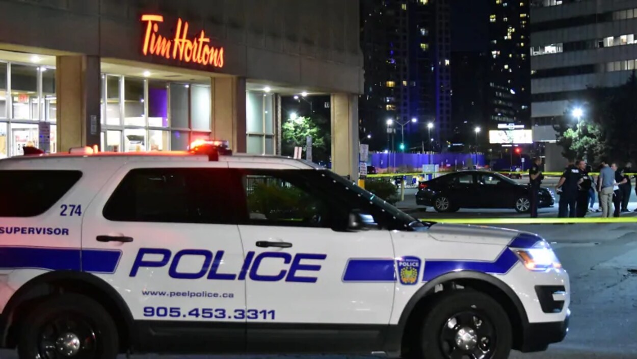 Un VUS de police devant un restaurant Tim Hortons, le soir.