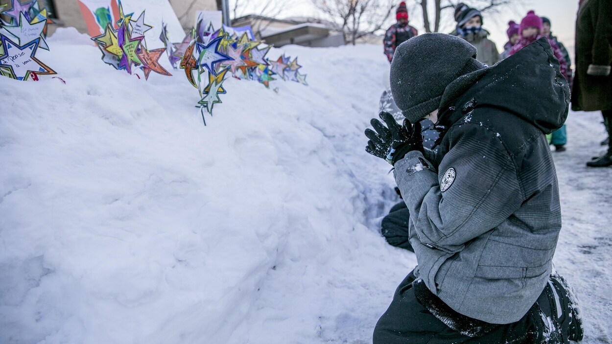 Des jeunes prient devant leurs messages aux victimes. Des jeunes prient devant leurs messages aux victimes.