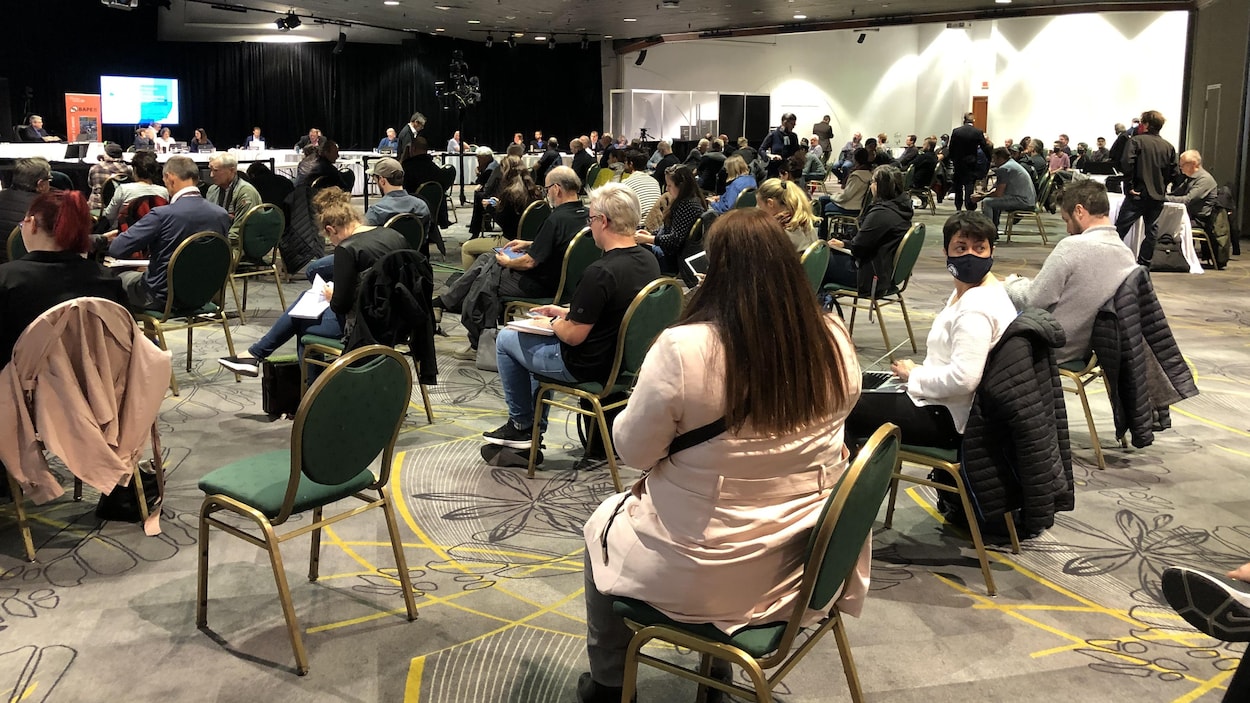 Des gens dans la salle où se déroulent les audiences du BAPE.
