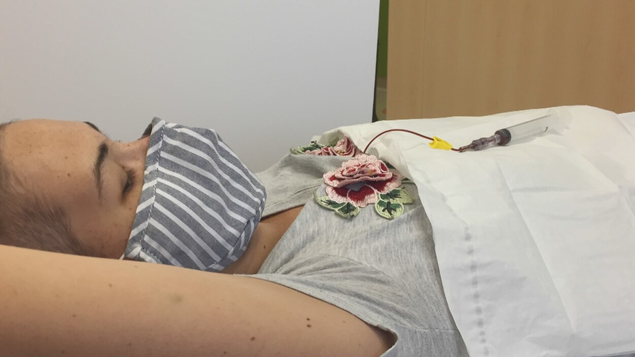 Aurélie Julien est couchée sur son lit d'hôpital pendant son traitement.