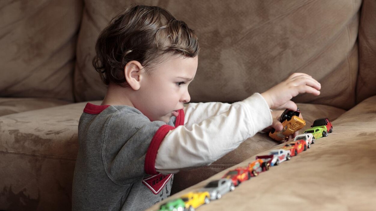 Un enfant autiste joue avec ses jouets Un enfant autiste joue avec ses jouets