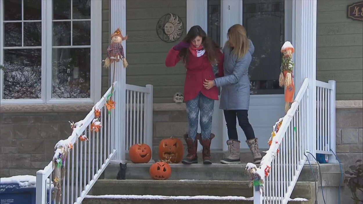 Deux femmes sortent d'une maison.