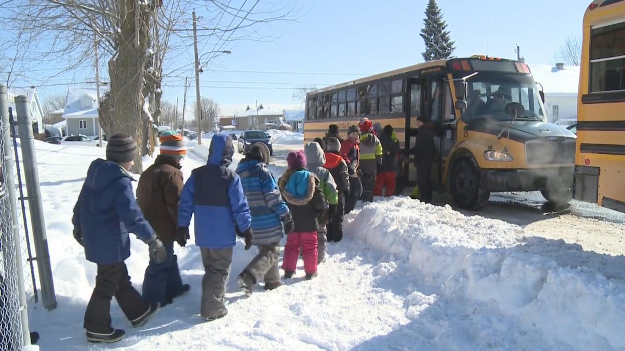 Des élèves s'apprêtent à monter à bord d'un autobus. Des élèves s'apprêtent à monter à bord d'un autobus.