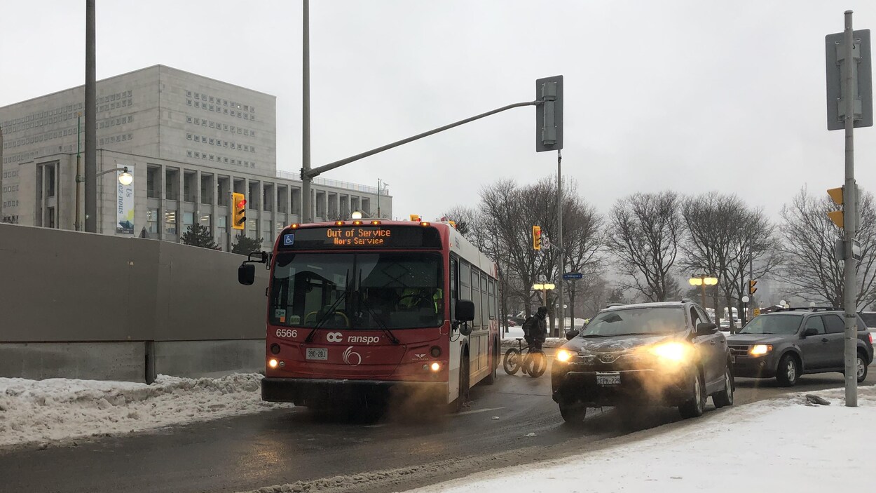 L'autobus prend un virage assez large dans la voie de gauche.