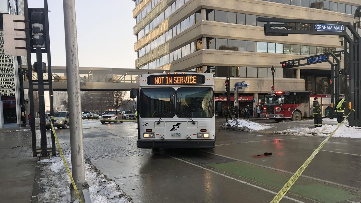 Un autobus stationné au milieu d'une intersection, à côté d'une botte dans une tâche de sang Un autobus stationné au milieu d'une intersection, à côté d'une botte dans une tâche de sang