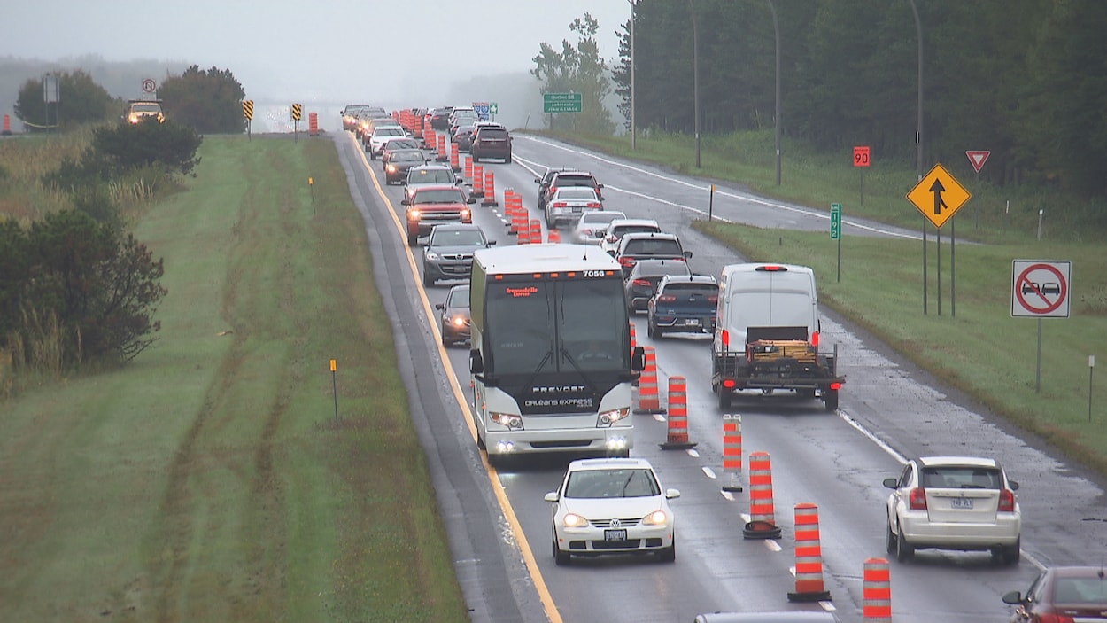 Des voiture roulent au ralenti sur un seul côté de l'autoroute 20.