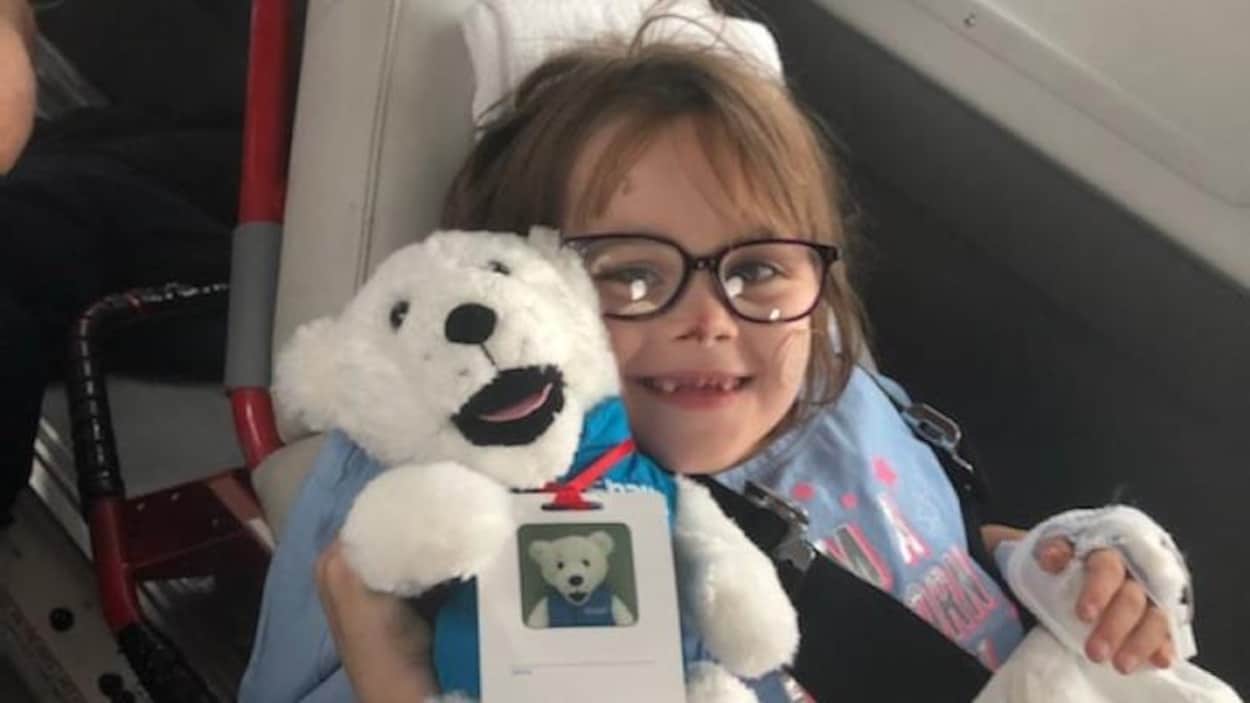 Autumn Ferguson sourit en tenant un ourson en peluche.