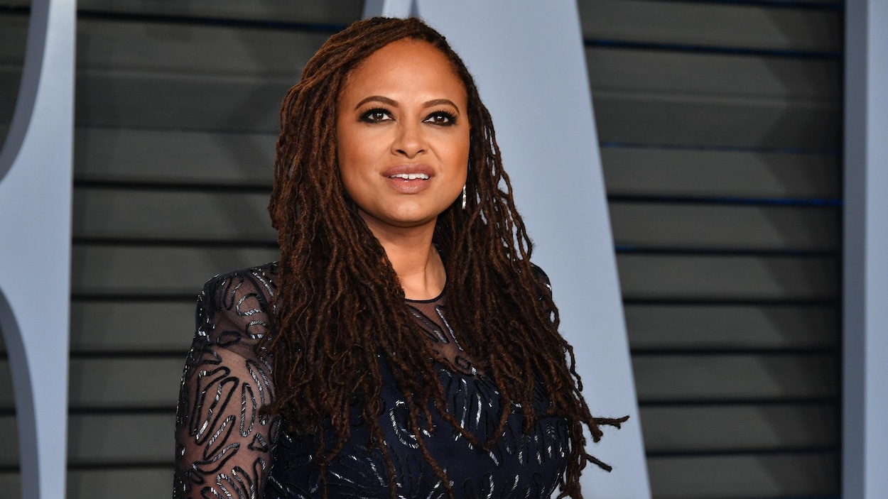 La réalisatrice et productrice Ava DuVernay, vêtue d'une robe bleu nuit, prend la pose sur le tapis rouge de la fête organisée par le magazine Vanity Fair après la cérémonie des Oscars. La réalisatrice et productrice Ava DuVernay, vêtue d'une robe bleu nuit, prend la pose sur le tapis rouge de la fête organisée par le magazine Vanity Fair après la cérémonie des Oscars.