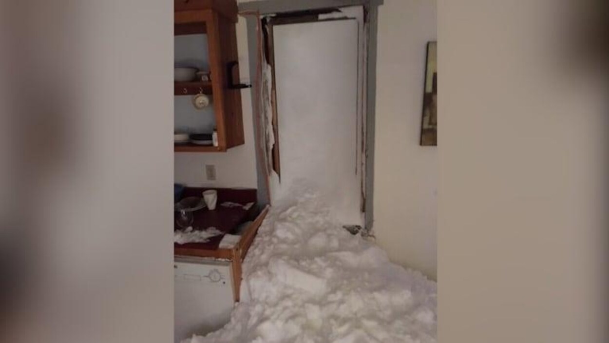 Une maison envahie de neige.