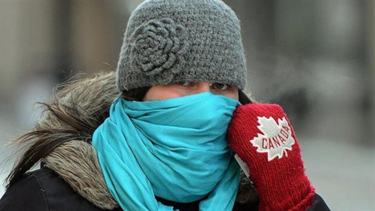 Une femme se couvrant le visage par temps froid.