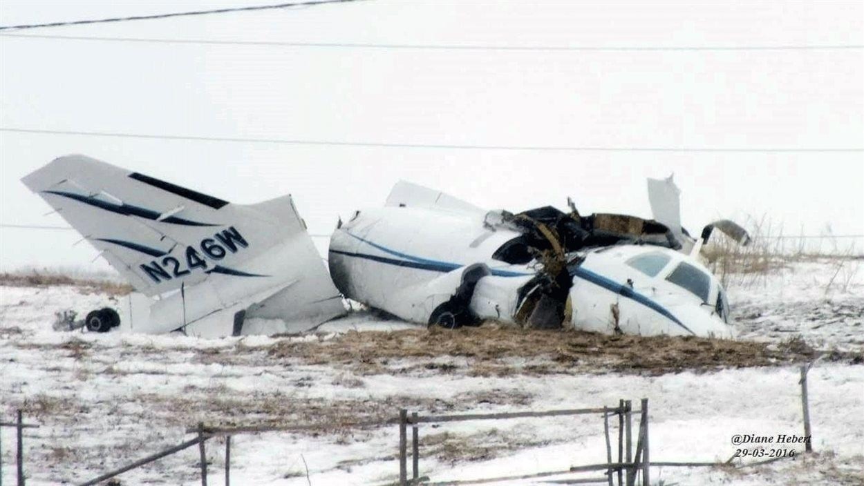 Carcasse de l'avion dans un champ enneigé.