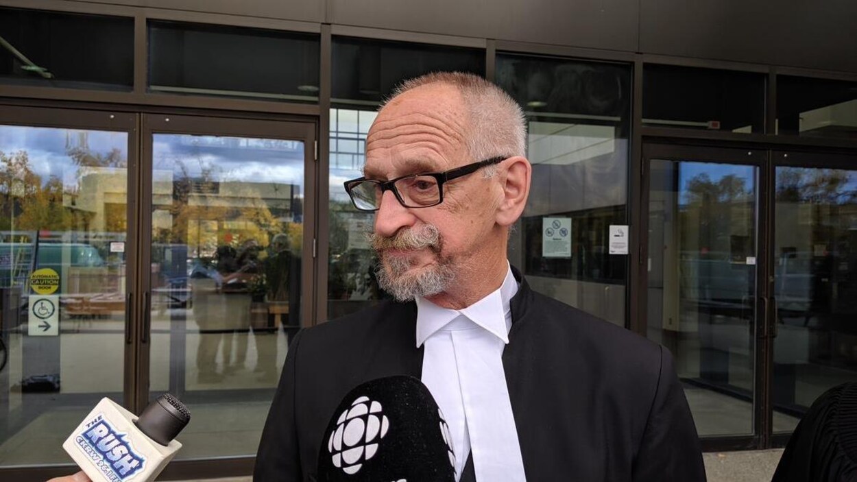 Un avocat répond aux questions de journalistes.