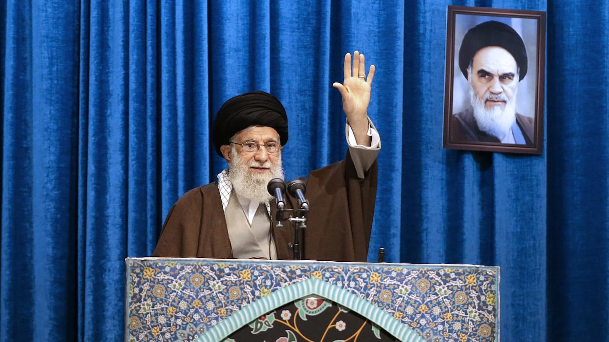 L'ayatollah lève le bras gauche pour saluer les fidèles.