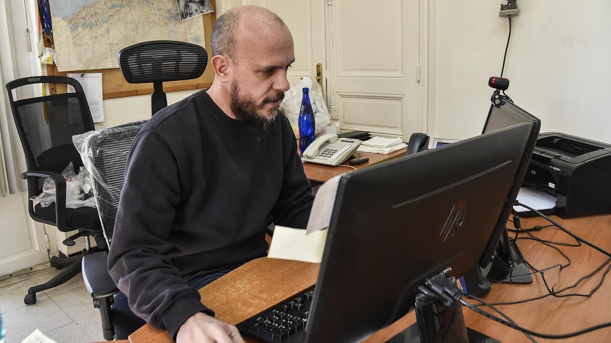 Aymeric Vincenot, assis à un bureau, devant un ordinateur.