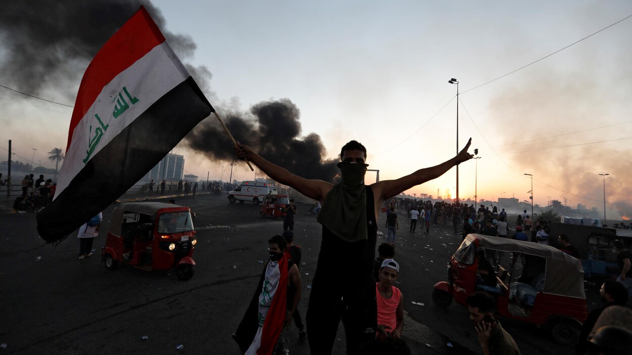 Un manifestant brandit un drapeau irakien lors d'une manifestation à Bagdad, le 5 octobre 2019.