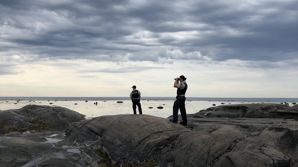 Des agents du ministère des Pêches et des Océans sur les rochers de Baie-des-Homards.