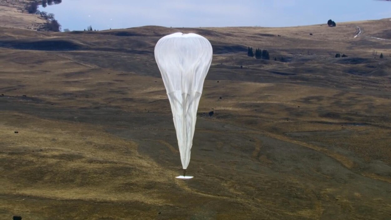 On voit un ballon servant aux télécommunications flotter dans les airs. On voit un ballon servant aux télécommunications flotter dans les airs.