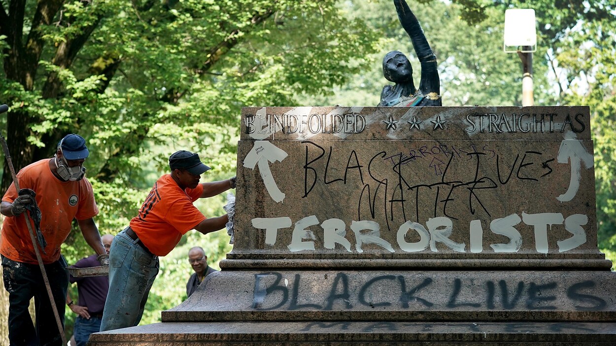 Des employés de la Ville de Baltimore, aux États-Unis, effacent des graffitis sur un piédestal où se tenait une statue de Robert E. Lee et Thomas « Stonewall » Jackson. On peut y lire « terroristes » et « les vies noires sont importantes ». La Ville de Baltimore a retiré la statue en douce, pendant la nuit, dans la foulée des violences de Charlottesville.