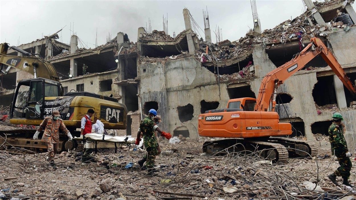 Les secouristes transportent le corps d'une victime découverte dans les décombres du Rana Plaza, deux semaines après son effondrement, au Bangladesh