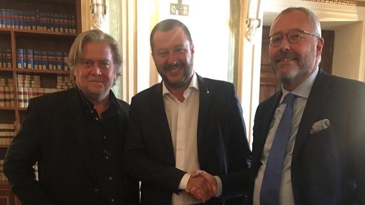 Trois hommes sont rassemblés dans une même pièce.