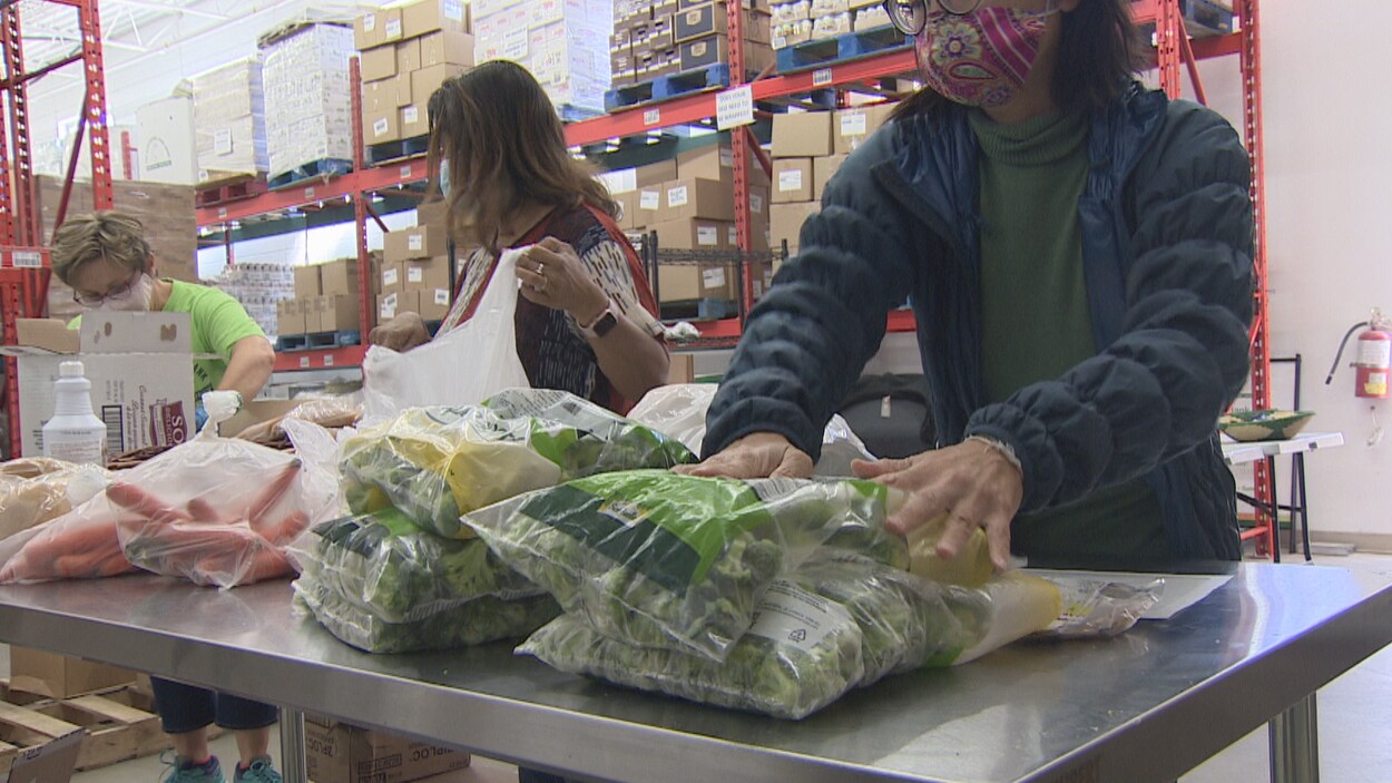Des employées et bénévoles préparent des denrées dans une banque alimentaire.