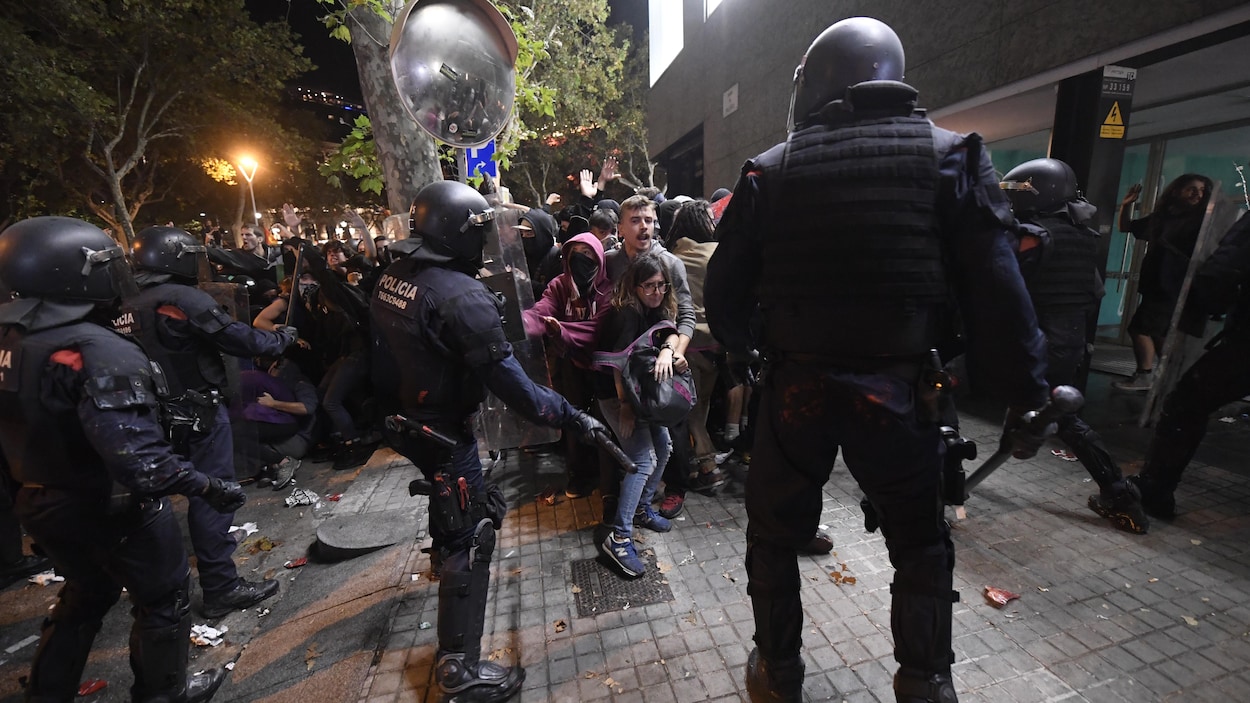 Des manifestants reculent devant les policiers antiémeutes.