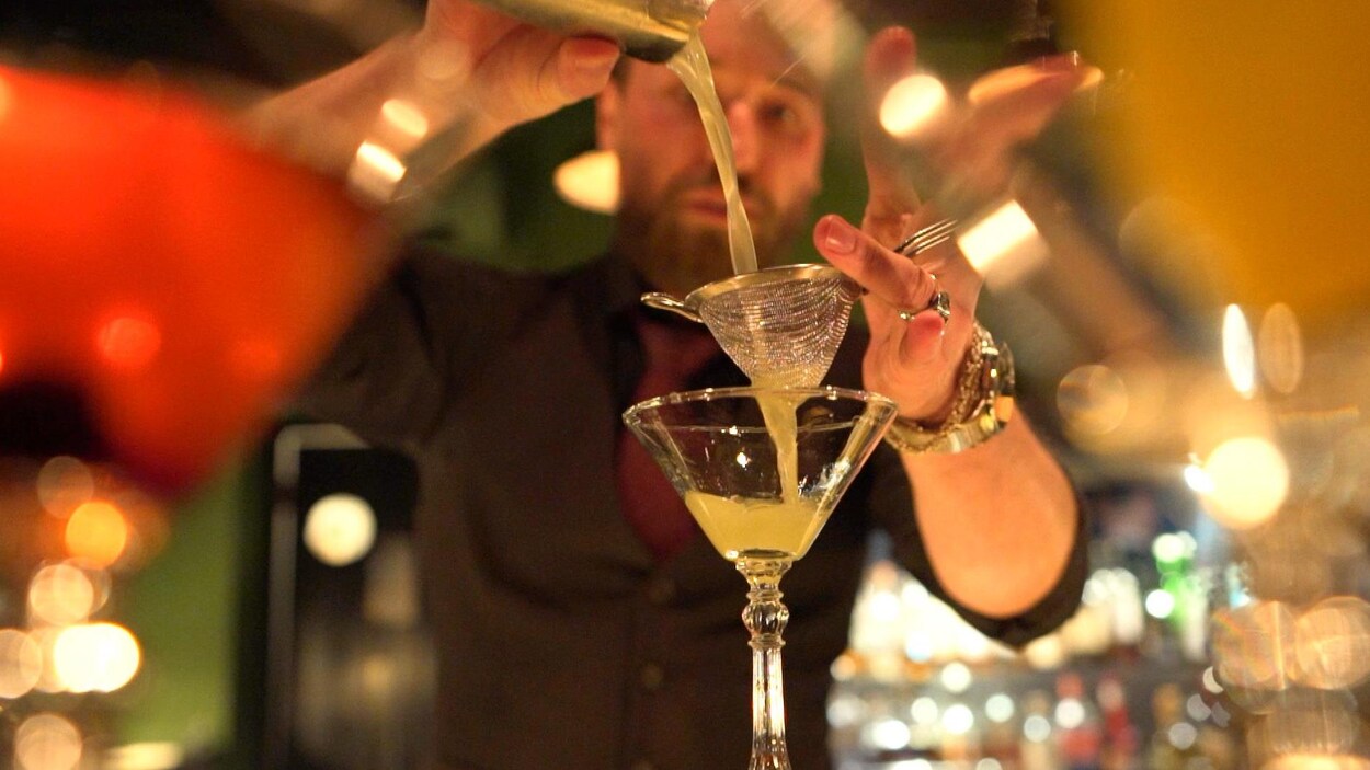 Un barman russe prépare un cocktail dans un bar qui est ouvert, en dépit de l'interdiction des autorités.