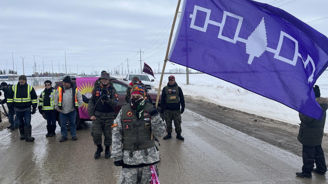 Des manifestants brandissant un drapeau.