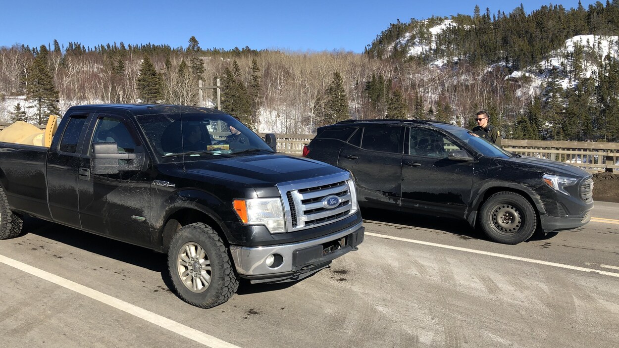 Des policiers posent des questions à ceux qui souhaitent monter à bord du traversier à Tadoussac.