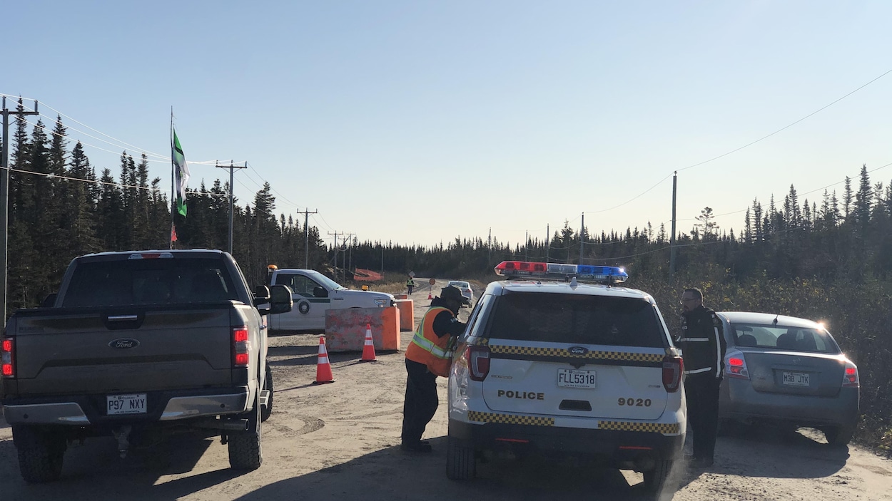Une personne à la barricade discute avec des policiers de la Sûreté du Québec.