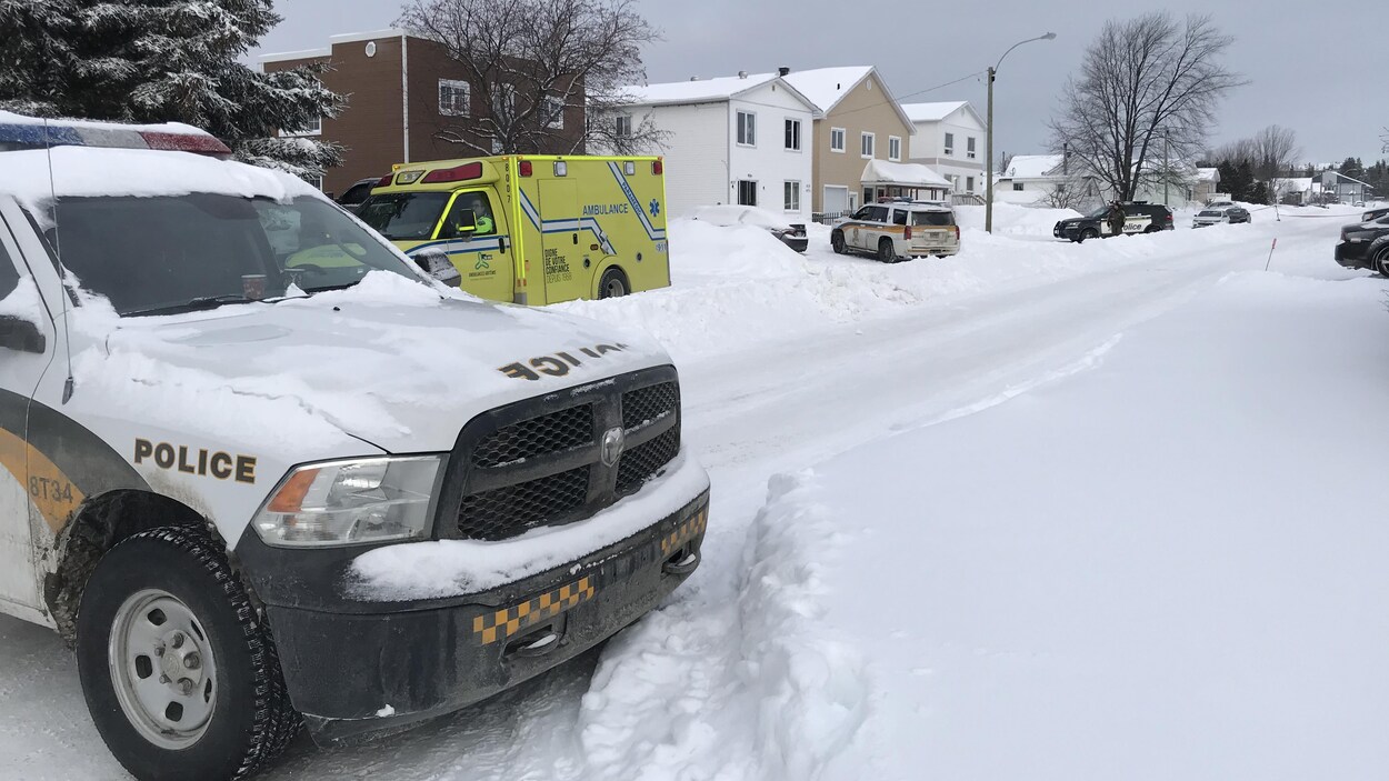 Trois voitures de la Sûreté du Québec et une ambulance sont stationnés sur une rue enneigée.