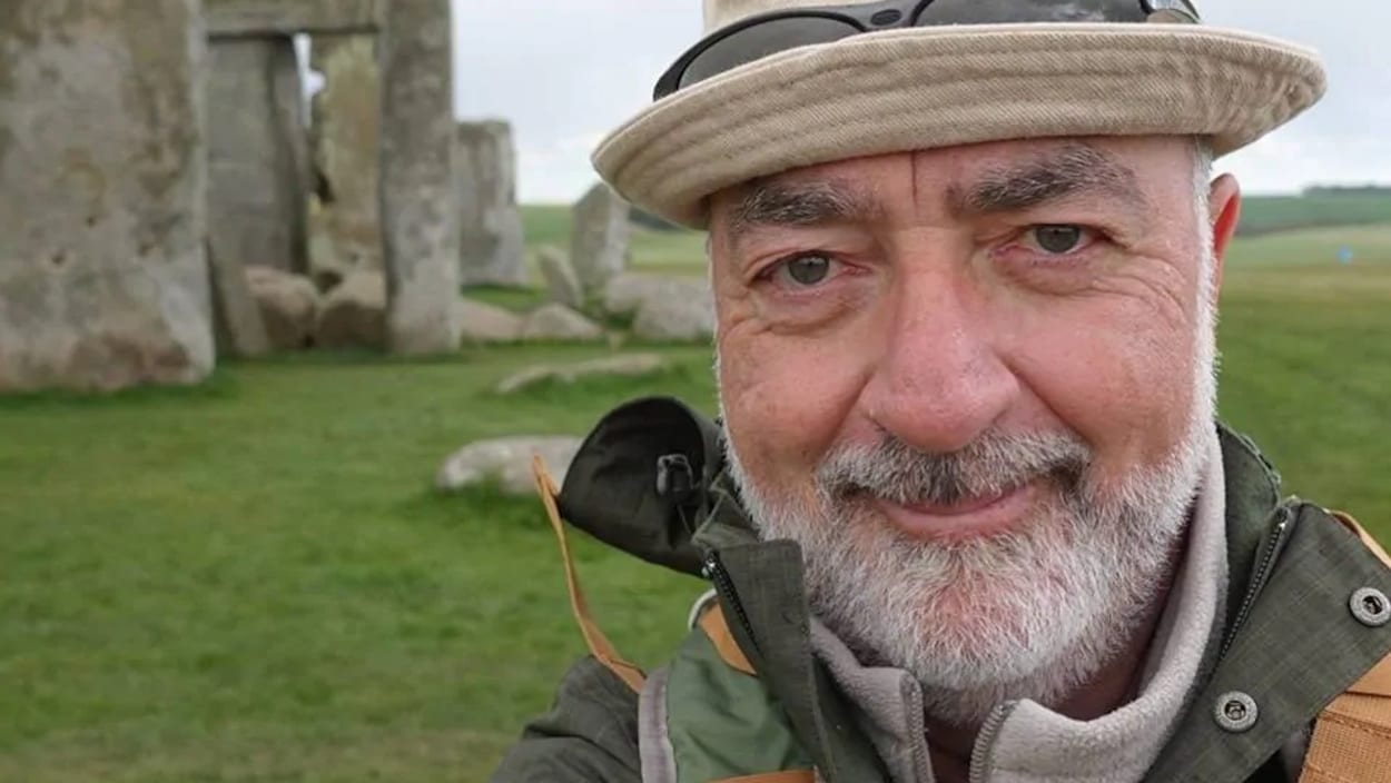 Un homme devant un monument en pierre.