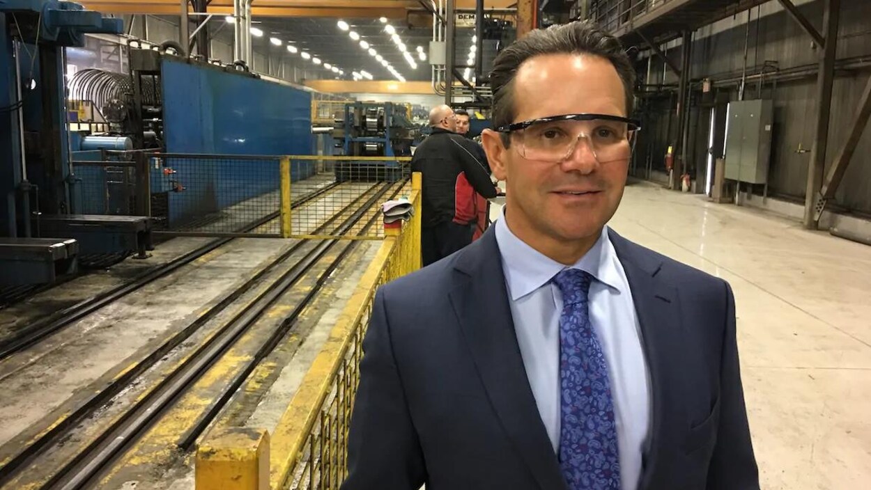 Un homme avec des lunettes de protection se trouve dans une usine.