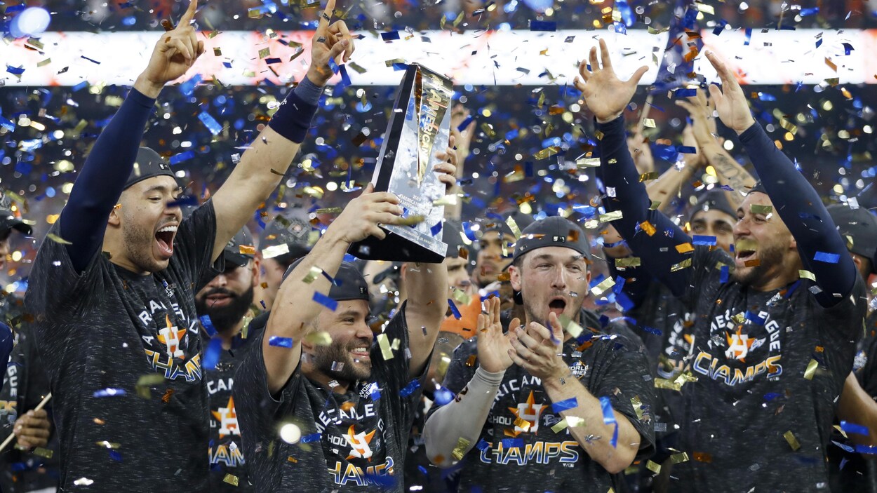 Entouré de ses coéquipiers, Jose Altuve soulève le trophée sur un podium envahi par les confettis.
