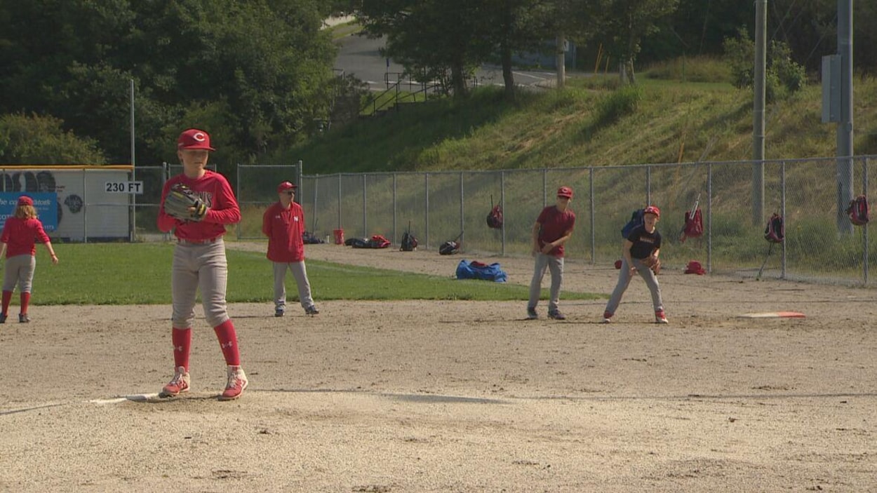 De jeunes joueurs de baseball sur un terrain.