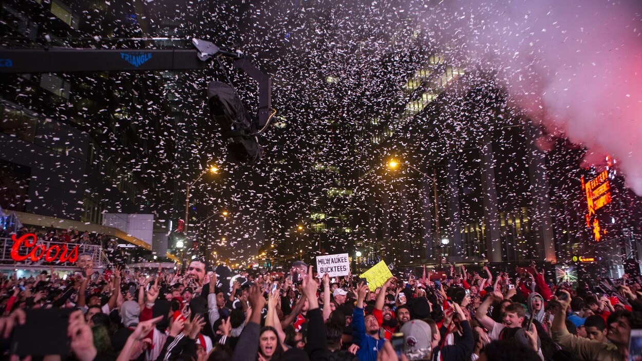 Des confettis pleuvent sur une foule rassemblée pour célébrer la victoire des Raptors de Toronto.