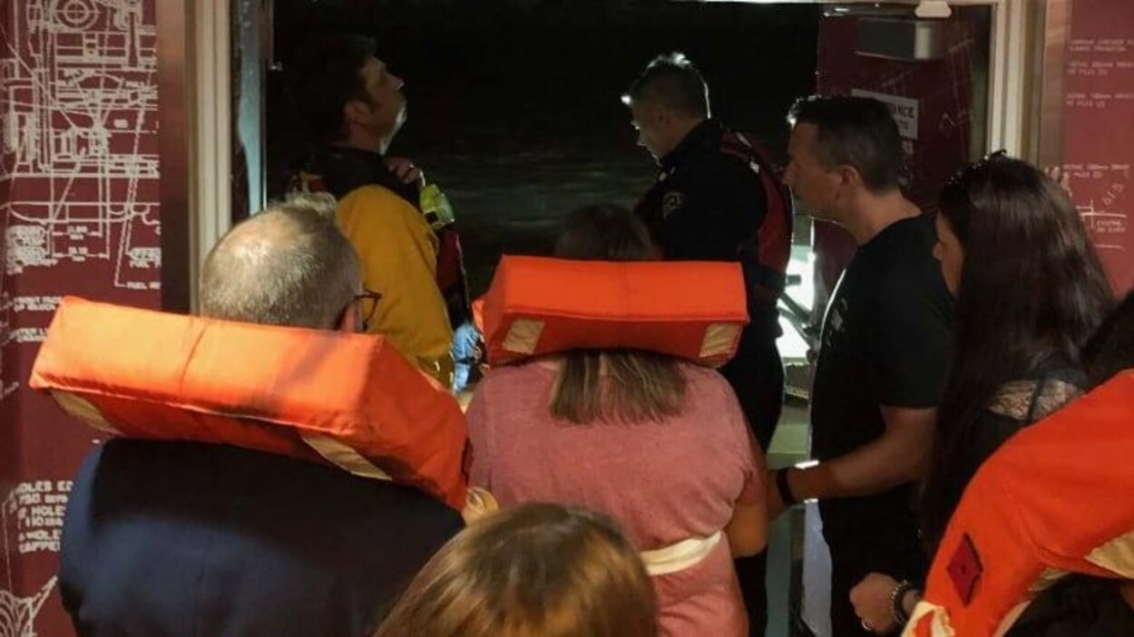 Des personnes portant de gilets de sauvetage dans un bateau de croisière.