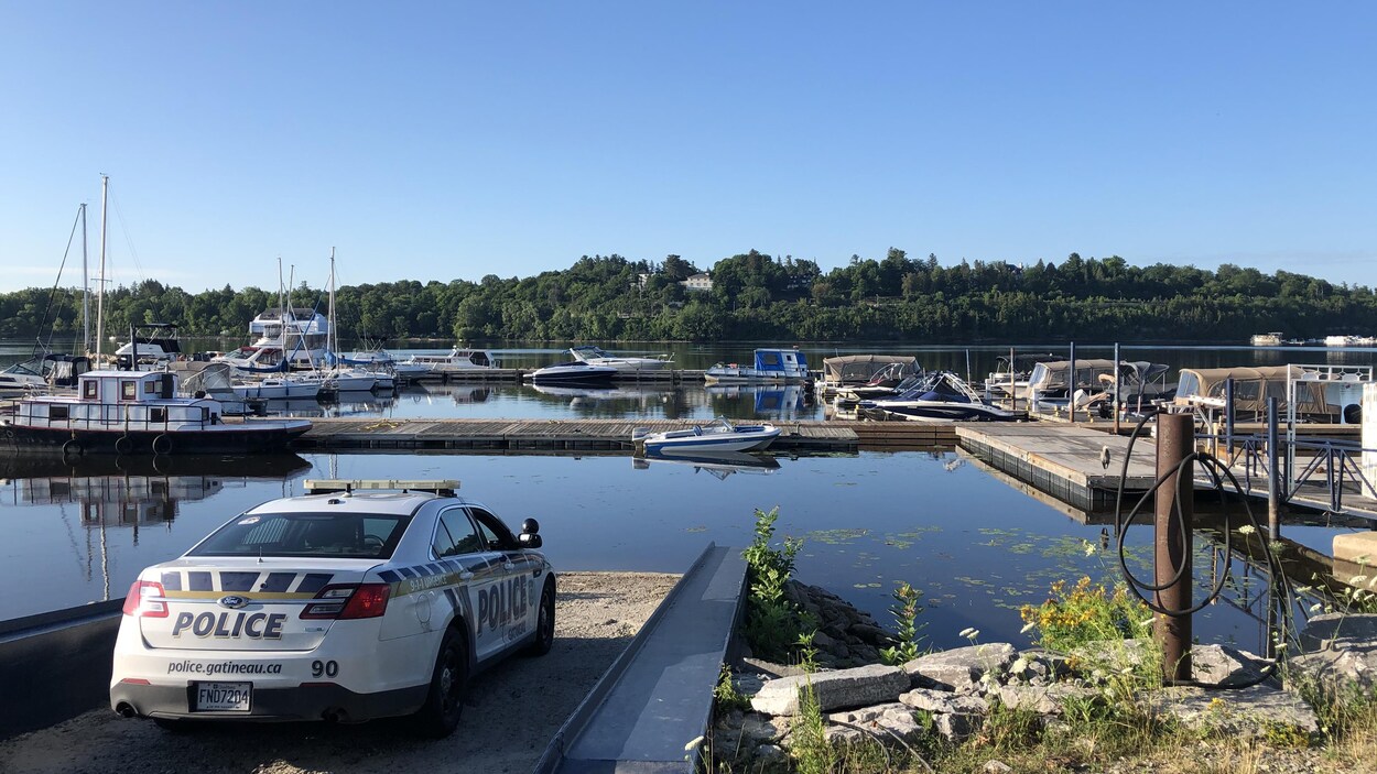 Une voiture du Service de police de la Ville de Gatineau est stationnée sur le quai d'embarquement de la marina.